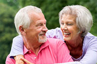 elderly couple smiling while looking at each other